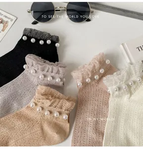 Close-up detail of sweet Japanese style women short socks with elegant lace ruffles and pearls.