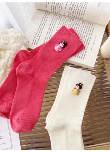 Detailed shot of cute vertical stripe mid-calf socks featuring sweet Tang style doll charm decor.