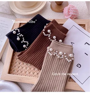 Close-up of stylish women knit mid-tube socks featuring delicate pearl wave cuff details.