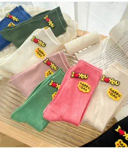 Trendy women's mid-calf ribbed socks with cute silicone letter charms, colorful stack style.