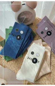 Colorful stacked knit mid-tube socks with cute smiley face and number print, casual cute style.