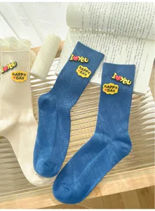Detailed close-up of ribbed mid-tube socks with cute silicone letter patches and soft knit.