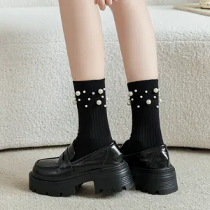 Chaussettes mi-hautes noires côtelées avec perles assorties à des mocassins compensés.