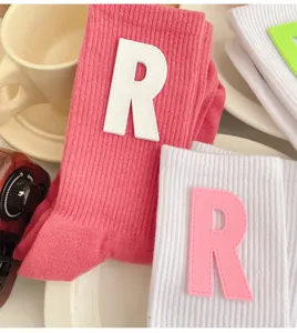 Cute pink and white mid-calf socks featuring soft letter R patches, Japanese ins style daily wear.