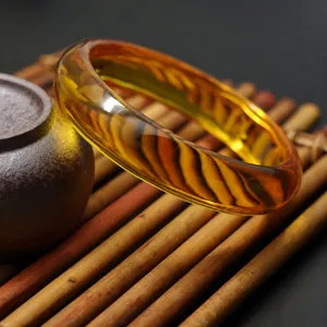 Detailed view of a golden amber synthetic beeswax bangle bracelet showcasing natural swirl patterns.