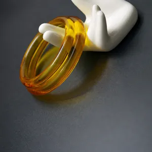 Synthetic amber resin bangle detail showing the golden honey texture and smooth round single loop design.