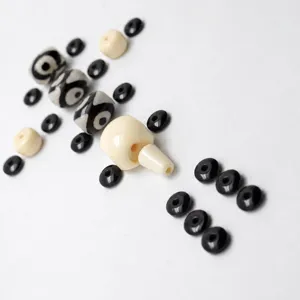 Détail d'accessoires de perles DIY, ensemble de perles sculptées noires et blanches.