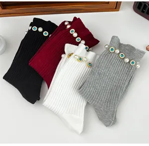 Detailed view of women's mid-tube socks featuring pearl and blue rhinestone floral decorations.