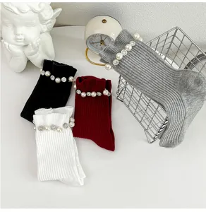 Vue détaillée de chaussettes mi-mollet en tricot avec élégant décor de perles et strass.