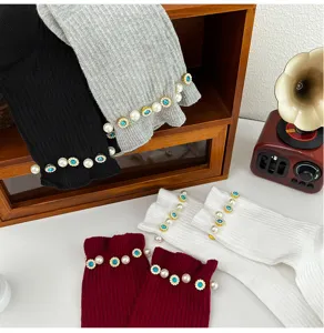 Detail view of women's ribbed knit socks featuring elegant pearl and blue crystal cuff decorations.