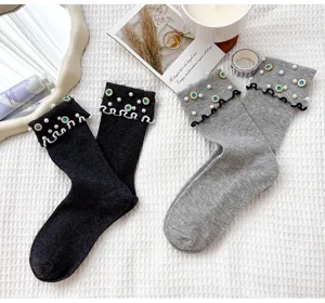 Detailed close up shot of cute women mid-tube socks featuring pearl rhinestone and lettuce edge.