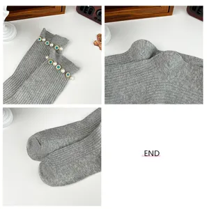 Grey ribbed women mid-tube socks featuring pearl and blue rhinestone decor detail closeup view.