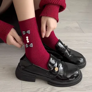 Sweet bow plaid socks paired with glossy leather shoes for women, stylish vintage look.