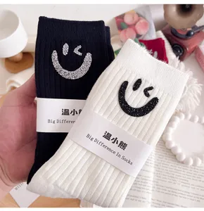 Detailed view of fashion vertical striped mid-tube socks with rhinestone winking smiley faces.