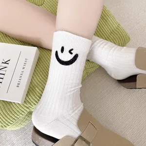 Comfortable white ribbed mid-tube socks featuring a sparkling rhinestone smiley face design.