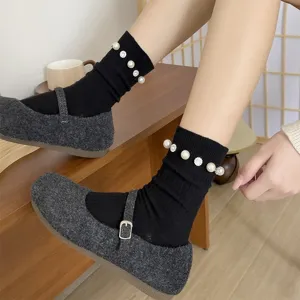 Chaussettes mi-hautes noires élégantes pour femmes avec ornements de perles et strass brillants.