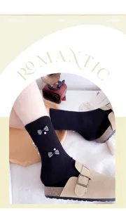 Detail view of dark gray women mid-tube socks featuring houndstooth bows and pearl decor.