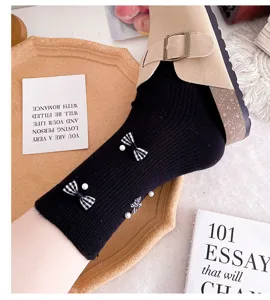 Detailed view of women's black mid-tube socks featuring cute houndstooth bows and pearl decorations.