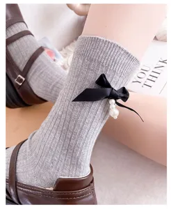 Grey ribbed mid-calf socks with black bow and pearl pendant, chic vintage style for women.