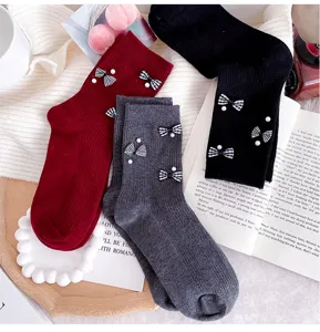Korean style women mid-tube socks featuring houndstooth bows and elegant pearl decorations.