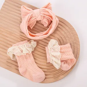 Grazioso set di fascia e calzini per bambina con volant in pizzo e design in maglia per neonati.