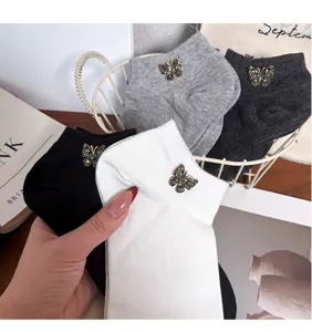 Detailed close-up of women short socks with rhinestone butterfly decoration, soft cotton.