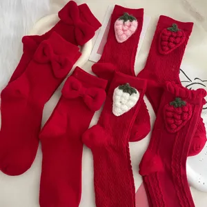 Red women's mid-calf socks with cute 3D knit strawberries and sweet bows for daily wear.