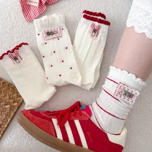 Cute white mid-tube socks with red polka dots, ruffles, and rabbit buttons for women.