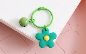 Leuk groen bloem sleutelhanger detail met lieve bel en metalen ring accessoire.