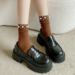 Braune gerippte Damensocken mit Perlen verziert, kombiniert mit schwarzen klobigen Loafern.