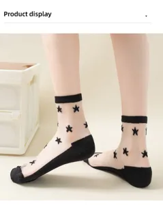 Sheer crystal silk socks detail view, showing black star pattern and reinforced cotton bottom.