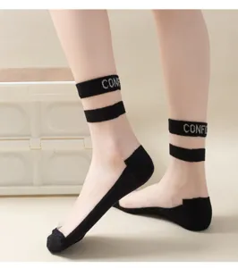 Close-up view of sheer black crystal silk socks featuring dual stripes and stylish letter knit details.