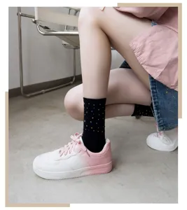 Detailed view of women black mid-tube socks featuring colorful rhinestone embellishments.