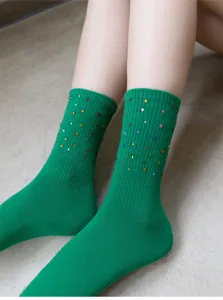 Detailed close-up of green mid-calf knit socks decorated with colorful sparkling rhinestones.