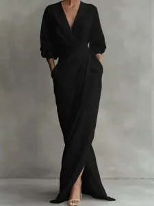 Elegant black maxi dress detail, featuring a deep V-neck, long sleeves, and practical pockets.
