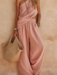 Detail view of stylish pink cotton linen one-shoulder sleeveless top and matching trousers set.