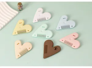 Primer plano de peines de corte de pelo coloridos en forma de corazón para flequillo.