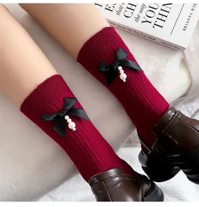 Red ribbed mid-calf socks for women featuring black bow and elegant pearl pendant design.