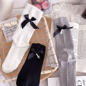 Women cotton mid-tube socks featuring chic black bows and pearl pendants, stylish trendy wear.