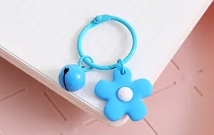 Schattige blauwe bloem sleutelhanger met bel, creatieve tas accessoire detailweergave.