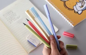 Gedetailleerd shot van kleurrijke inktloze eeuwige potloden in pastelteinten in de hand voor kunst.