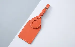 Close-up detail of orange PU leather luggage tag designed for AirTag tracker holder.