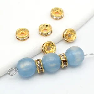 Nahaufnahme von 18K vergoldeten Strass-Abstandsperlen und blauen Rundperlen für DIY Schmuck.