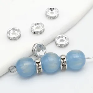 Nahaufnahme von hellblauen Perlen und silbernen Strass-Abstandshaltern für Schmuck.