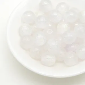 Close-up view of translucent glitter resin round beads for DIY jewelry making crafts.
