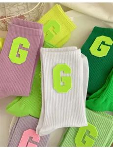 Detail shot of colorful knit socks featuring a stylish collegiate G letter patch and high elasticity.
