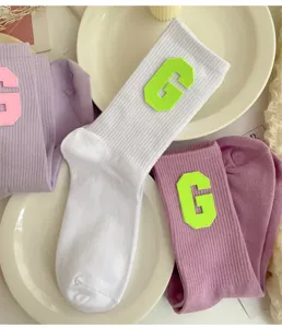 Stylish collegiate style women crew socks featuring letter G patches for daily wear.