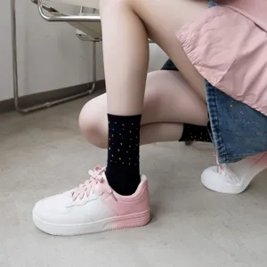 Black rhinestone mid-tube socks paired with pink gradient sneakers for a chic women's look.