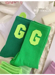 Green varsity style cute mid-tube socks with bold letter G patch for women spring summer.
