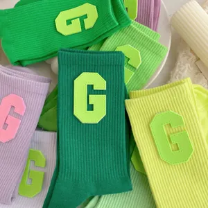 Women's mid-tube socks featuring vibrant colors and trendy letter G patch for daily wear.